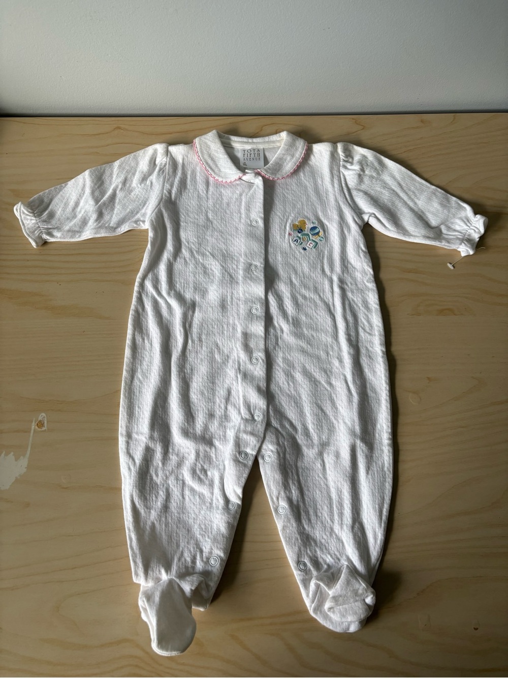 White Footed One-Piece with Pink Trim and Floral Embroidery